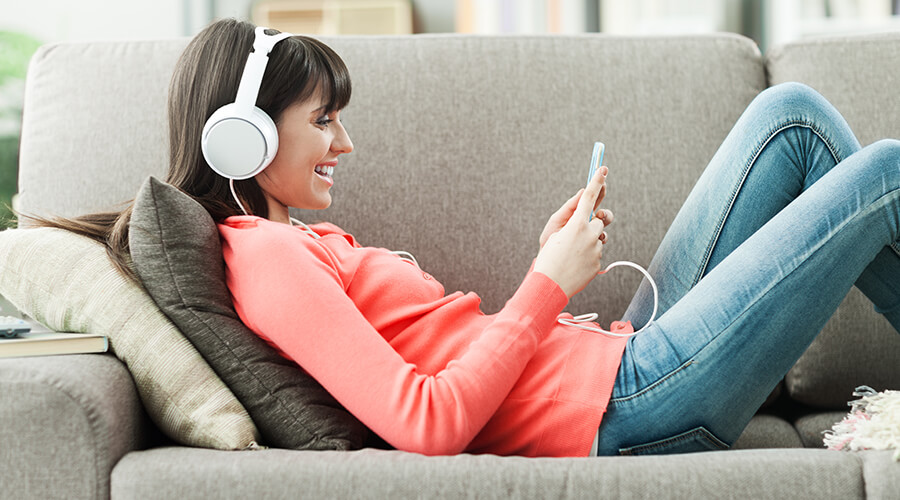 Woman on sofa wearing headphones